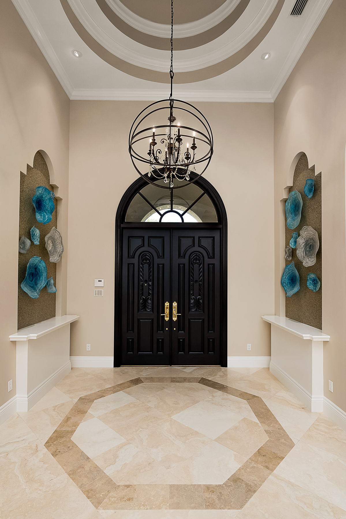 The focal point at the entrance features 2 large niches with hand blown glass bowls custom designed by a local artist