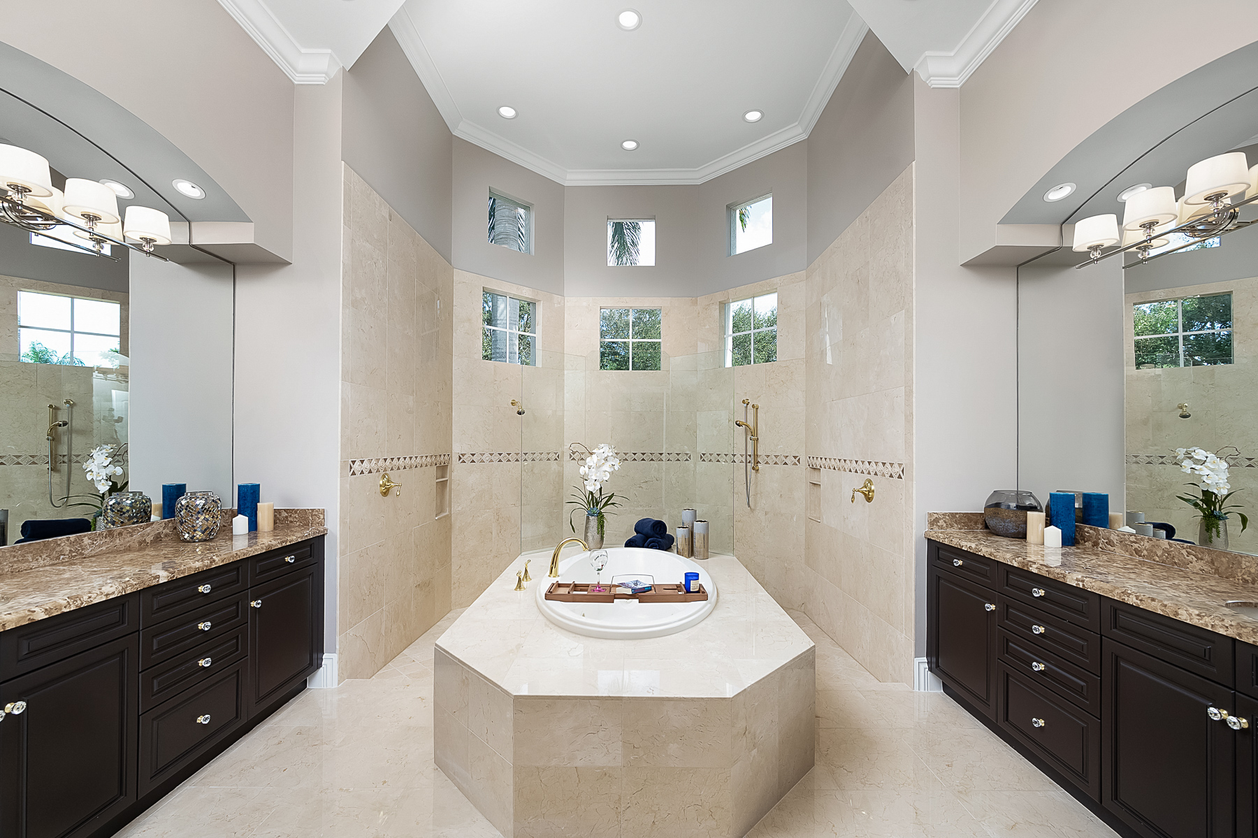 Master suite bath includes a large walk-through shower with honed stone tiles on the walls and floors as well as glamorous soaking tub to take a relaxing bubble bath in